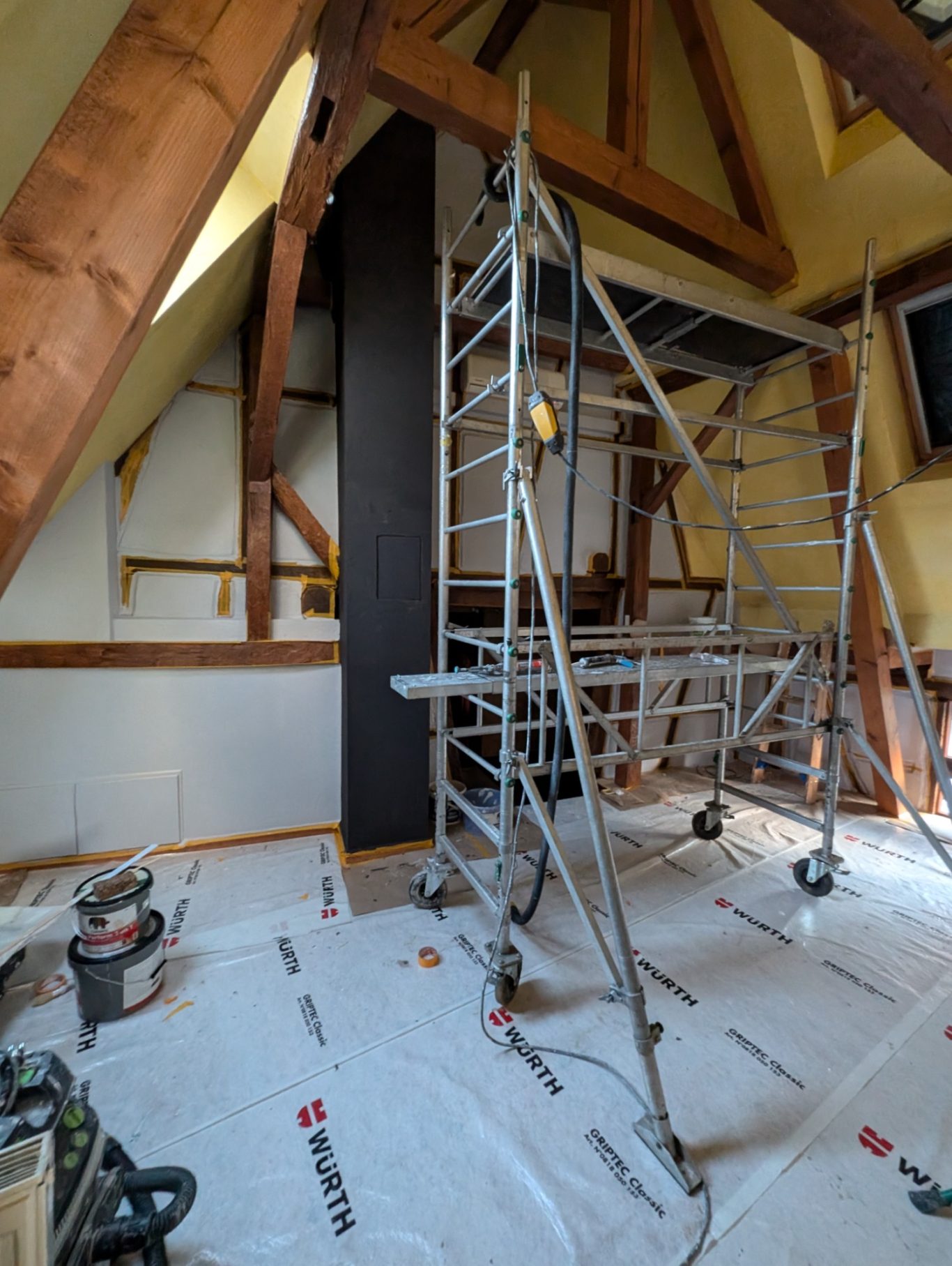 Avant - Grande chambre colombage Échafaudage en cours d'installation dans une pièce en cours de rénovation.