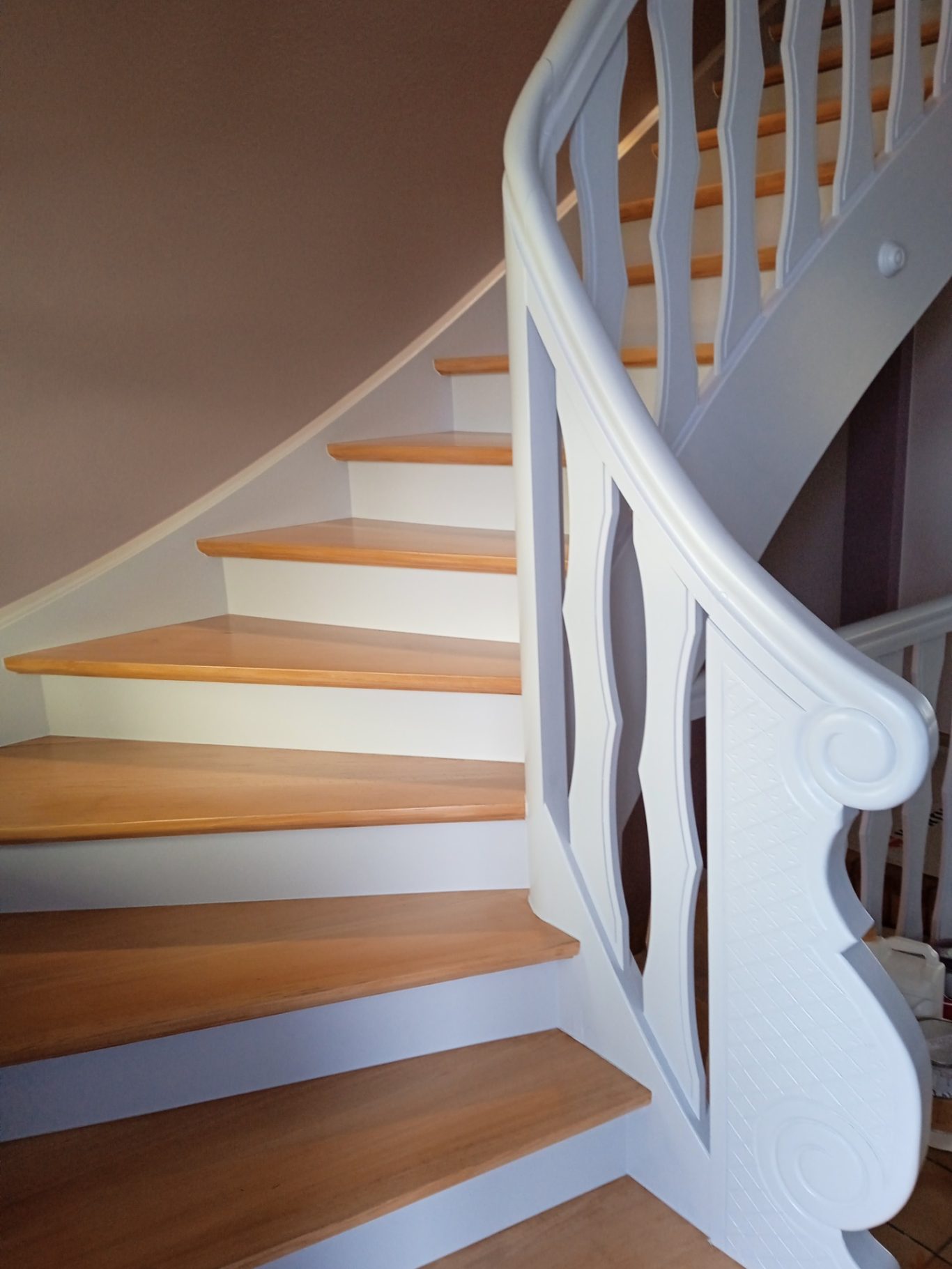 Après - escalier peint Escalier en bois avec balustrade blanche, courbant vers le haut.